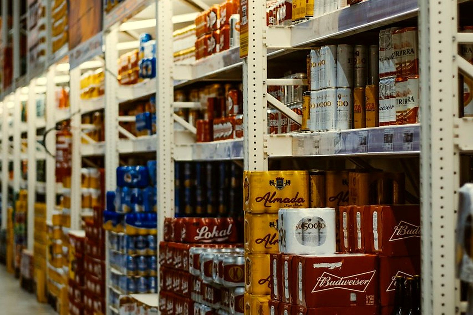 Free Rows of beer and beverages stacked neatly in a supermarket aisle. Stock Photo